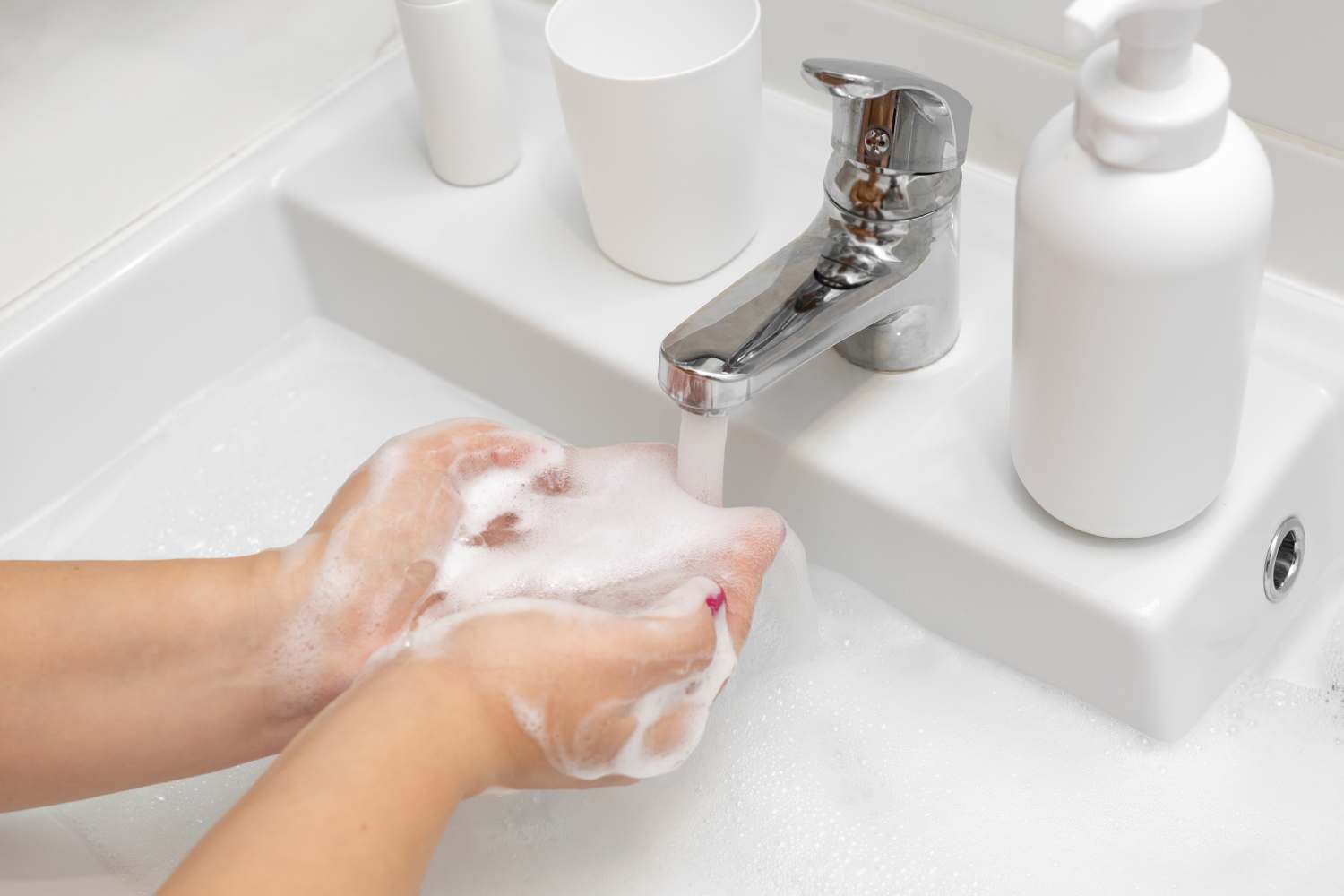 Kobieta myję ręce mydłem w płynie w toalecie publicznej