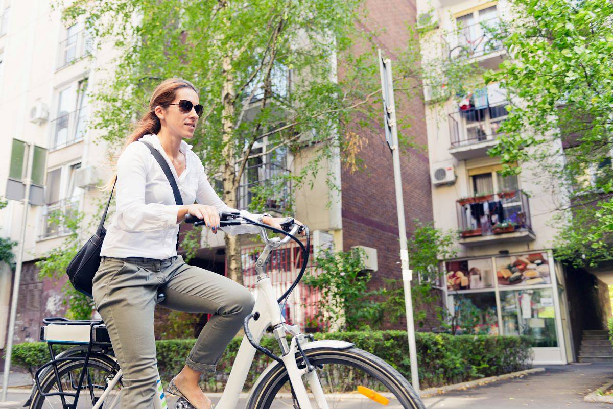 Kobieta jedzie rowerem elektrycznym do pracy