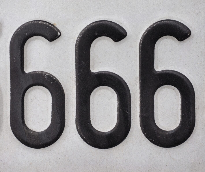 Na tym ujęciu widzimy trzy czarne cyfry 6 ułożone obok siebie w jednej linii. To charakterystyczny symbol liczby 666, która jest związana z różnymi wierzeniami i kulturami. Cyfry są bardzo wyraźne i kontrastują z białym tłem, co dodaje im jeszcze więcej znaczenia i symboliki. Całość prezentuje się bardzo mrocznie i tajemniczo, co podkreśla kontrowersyjny charakter tej liczby oraz jej związek z kulturą i religią. Symbolika liczby 666 wciąż budzi wiele kontrowersji, a jednocześnie jest częścią kultury i historii różnych narodów i społeczności.