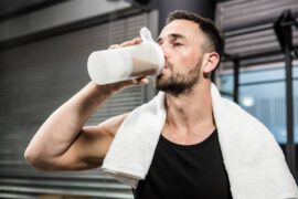 Mężczyzna pije odżywkę białkową