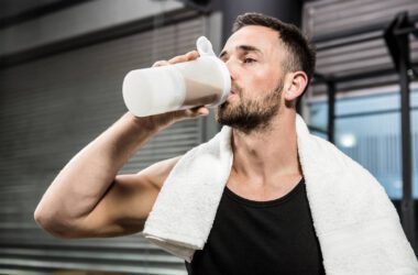 Mężczyzna pije odżywkę białkową