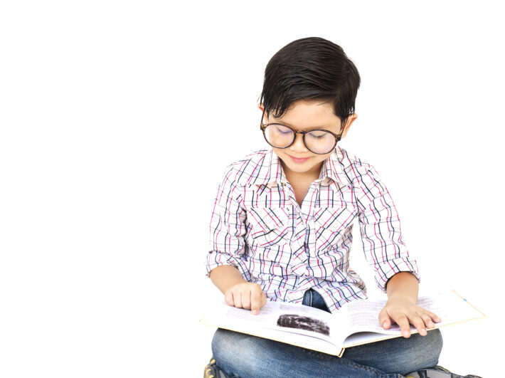 Ten ujmujący obrazek przedstawia małego chłopczyka w okularach, całkowicie pochłoniętego czytaniem. Z dużym skupieniem i zainteresowaniem przegląda strony książki, odkrywając świat literatury. Okulary, które nosi, podkreślają jego zaangażowanie w naukę i rozwijanie umiejętności czytania. Ten obrazek jest inspirującym przypomnieniem o sile czytania w młodym wieku oraz o możliwościach, jakie literatura otwiera przed małymi odkrywcami