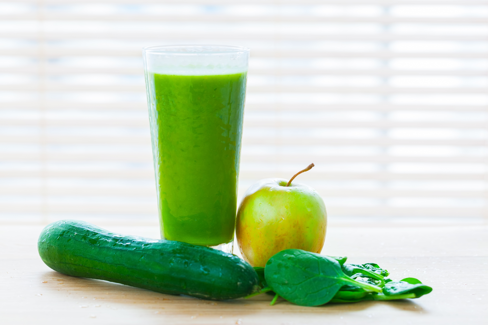 Na tym obrazku widać szklankę zawierającą orzeźwiający ielony sok warzywno-owocowy. Sok skomponowany z zielonych warzyw i soczystych owoców prezentuje intensywny kolor i zdrowy wygląd. To nie tylko smaczny napój, ale także pełen witamin i składników odżywczych, który doda energii i odświeży organizm