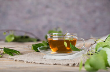 Na tym obrazku możemy zobaczyć filiżankę pełną aromatycznej herbaty z liści orzecha włoskiego, która zachwyca głębokim brązowym kolorem i intensywnym zapachem. Liście orzecha włoskiego unoszące się na powierzchni napoju dodają mu naturalnego uroku i świeżości. Ta wyjątkowa herbata nie tylko doskonale smakuje, ale również posiada liczne właściwości zdrowotne, wspierając nasze zdrowie i dobre samopoczucie dzięki swojemu bogactwu składników odżywczych i antyoksydantów