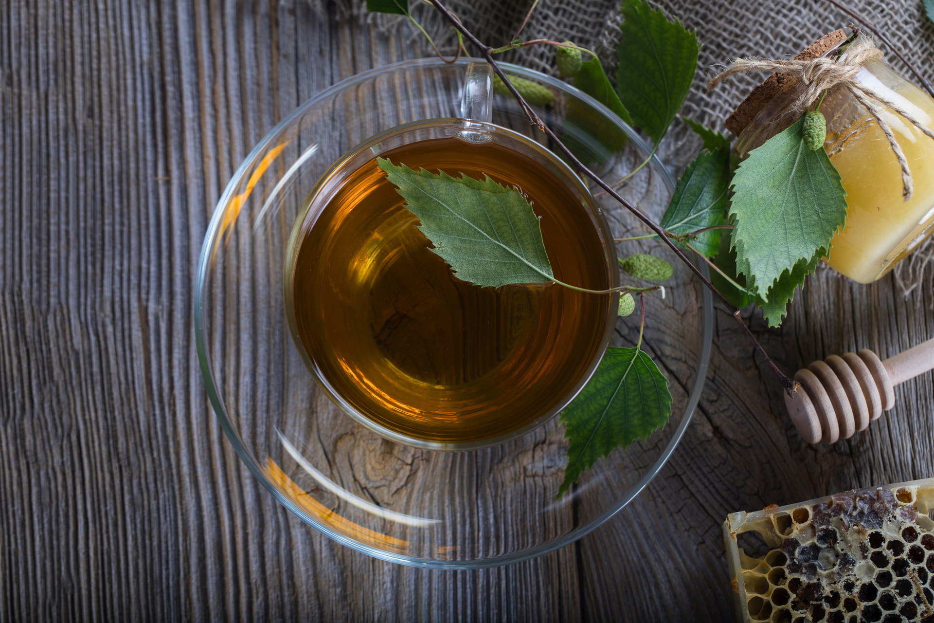 Na tym obrazku widoczna jest delikatna filiżanka herbaty z liści orzecha włoskiego, której barwa przypomina złocisty bursztyn. Aromatyczny bukiet unosi się z napoju, tworząc przyjemną atmosferę relaksu i odprężenia. Ta wyjątkowa herbata nie tylko koi podniebienie swoim delikatnym smakiem, ale również oferuje liczne korzyści zdrowotne, wspierając nasz organizm swoimi wartościami odżywczymi i antyoksydacyjnymi