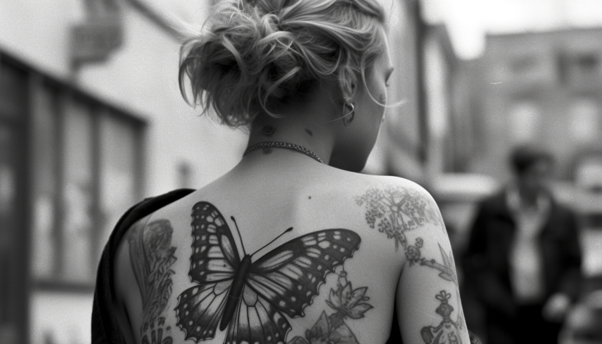 Na obrazku widoczny jest tatuaż z motylem umieszczonym na plecach kobiety. Motyl, symbol transformacji i delikatności, pięknie ozdabia jej skórę, dodając jej wyjątkowego uroku. Ten artystyczny motyw na plecach kobiety jest nie tylko estetyczny, ale również wyraża jej osobiste znaczenie i indywidualność
