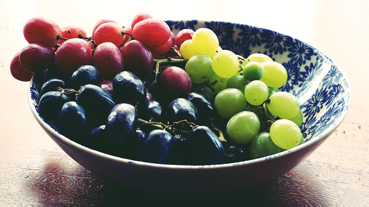 Trzy kolorowe winogron w misce 