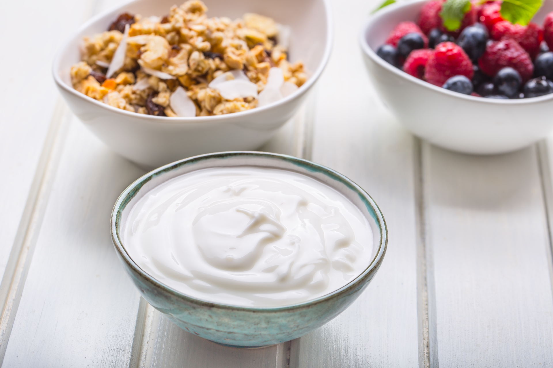 Na obrazku można zobaczyć miseczkę z pysznym jogurtem naturalnym. Jego gładka i kremowa tekstura oraz biały kolor zachęcają do skosztowania. Jogurt naturalny jest nie tylko smaczny, ale też bogaty w białko i probiotyki, co czyni go zdrowym wyborem na codzienny posiłek