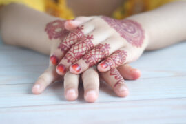 Dłonie kobiety ozdobione czerwonymi tymczasowymi tatuażami, dodają one wyrazistości i oryginalności